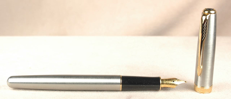 Silver fountain pen with gold nib and cap.