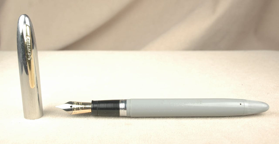 Gray fountain pen with silver cap.