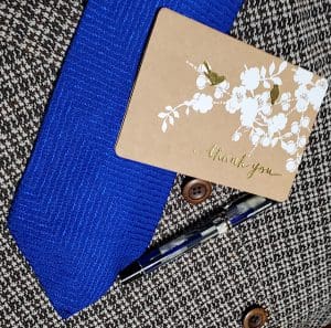 Tie, thank you card, and pen on fabric.