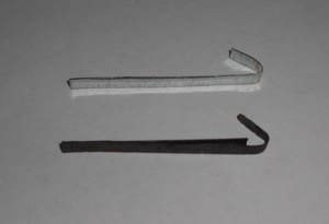 Two metal tension wrenches on gray background.