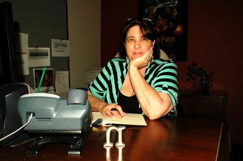 Woman sitting at desk, striped shirt.