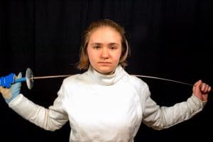 Fencer in white gear holding a sword.