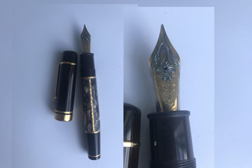 Black and gold fountain pen with nib.